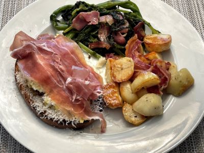 Italian brunch with scrambled eggs, pancetta potatoes, prosciutto and rapini